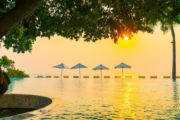 Parasol en stoel rond zwembad met uitzicht op zee oceaan voor vakantie vakantie reizen concept