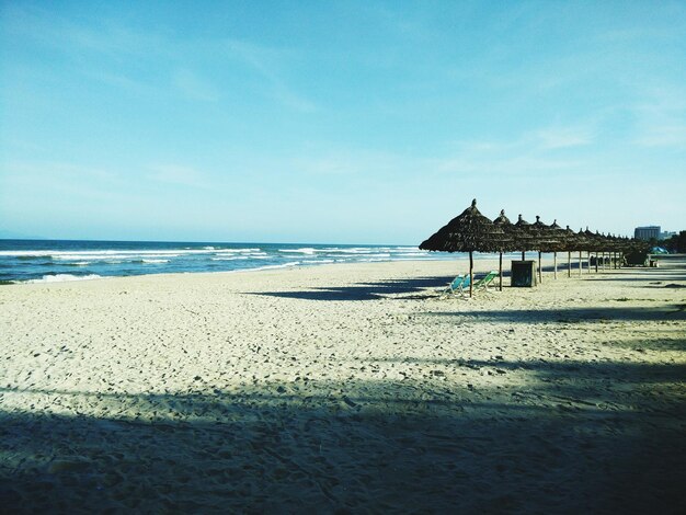 Parasols on beach against sky