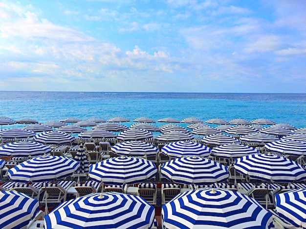 Photo parasols by sea against sky