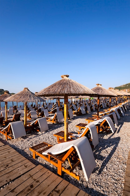 Parasols op een strand - de houten parasols met een grafiek die zich op het grondgebied van een strand bevinden