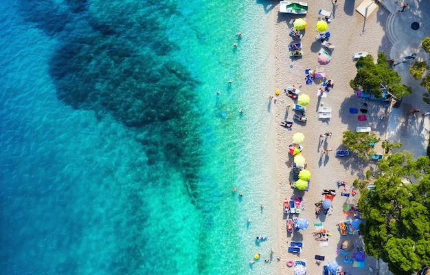 Parasols strand en zee als achtergrond van bovenaanzicht Azuurblauwe waterachtergrond vanuit de lucht Zomerzeegezicht Reisbeeld