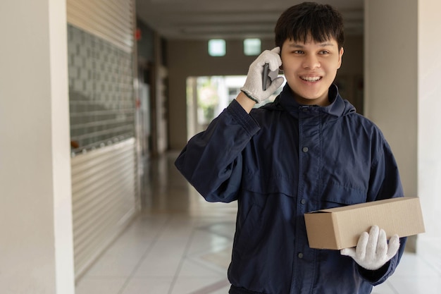 Parcel delivery concept the mail carrier standing in front of
the building and calling his customer