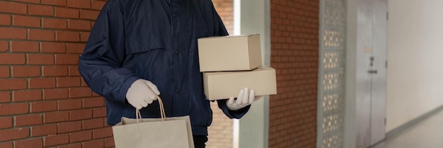 Фото Концепция доставки посылок постоянный почтальон в бледно-серой кепке, несущий одну сумку
