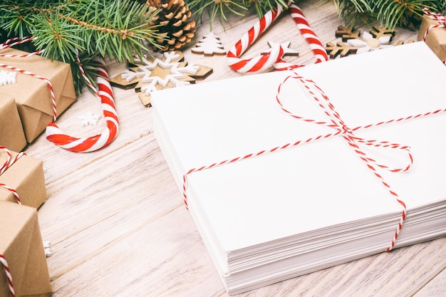 Посылка в конверте с еловыми ветками и рождественские украшения на деревянном фоне в тонах