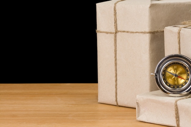 Parcel wrapped and compass isolated on black  wall