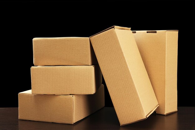 Parcels boxes on wooden table on black background