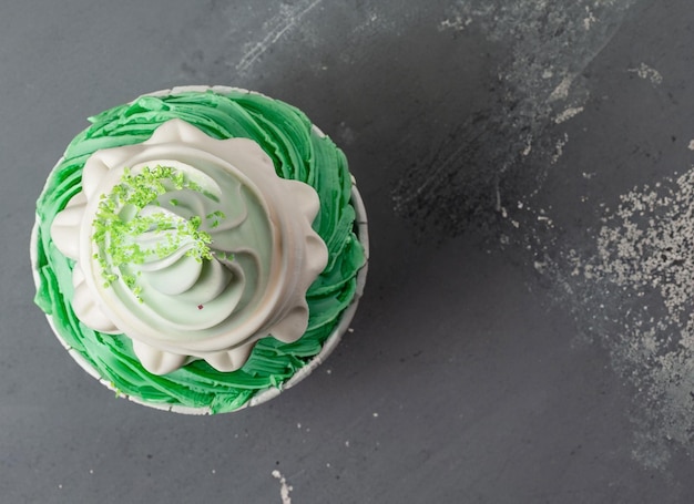 Parel verjaardag cupcake met roomboter slagroom op grijze achtergrond bovenaanzicht