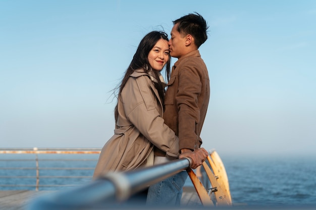 Foto paren die elkaar omhelzen in de buurt van de zee