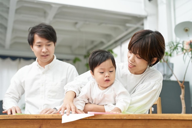 室内でオリガミをしている親と子供