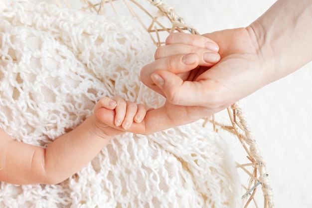 Parent hands holding newborn baby fingers Close up mother's hand holding their new born baby Love family healthcare and medical body part