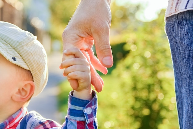 Родитель держит ребенка за руку на счастливом фоне