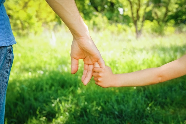 The parent holding the child's hand with a happy background