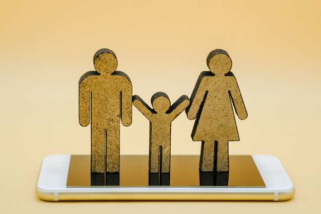 Parent Man, woman and child wooden icon on smart phone.