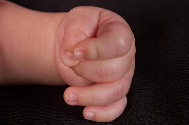 Родительская рука держит новорожденного