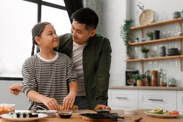 写真 子どもに寿司を作る方法を教える親