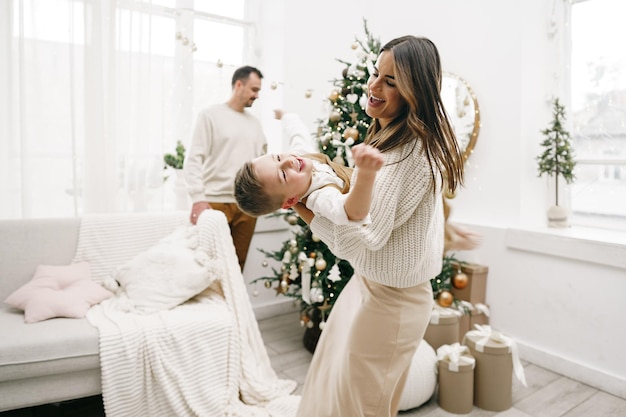 親とその幼い息子は、クリスマスの時期に屋内で楽しんで一緒に遊んでいます