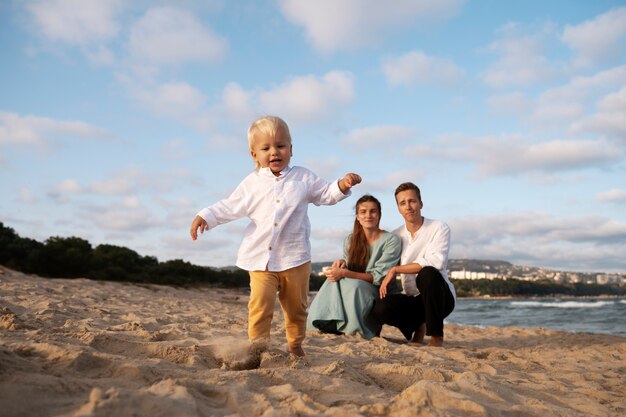 Photo parent with a baby on the beach at sunset