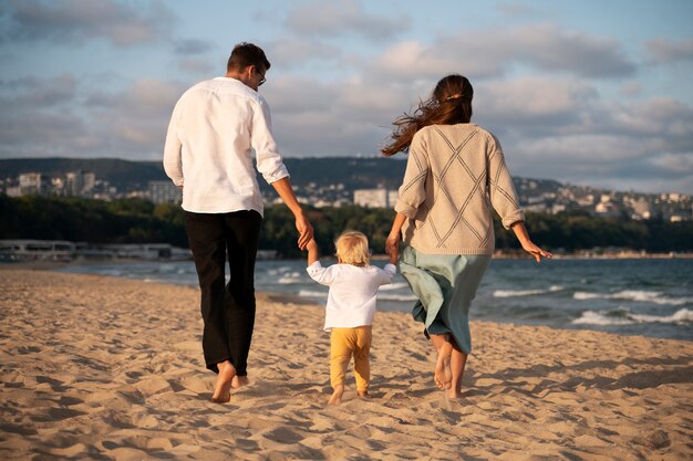 Foto genitore con un bambino sulla spiaggia al tramonto