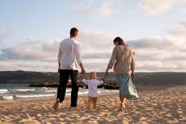 Foto genitore con un bambino sulla spiaggia al tramonto