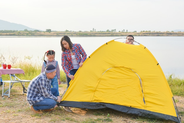 Foto genitore con bambini che sistemano la tenda in campeggio avventura di attività all'aperto per famiglie in vacanza