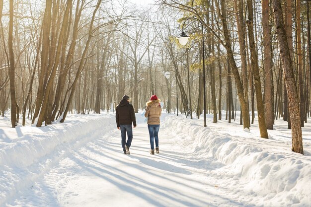 Parenthood, fashion, season and people concept. happy family with child in winter clothes outdoors