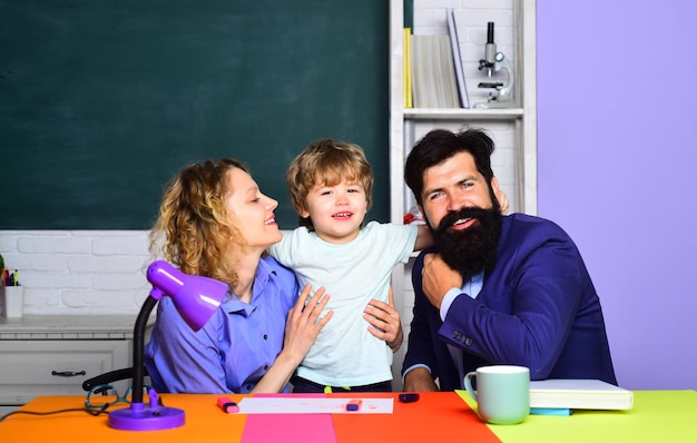 幸せな家族の子供たちの教育のお母さんとお父さんの子育ては、学校の生徒に初めて子供男の子を助けます