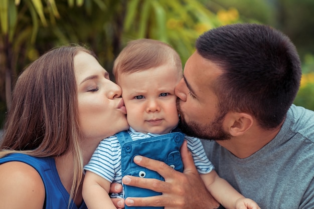 Родители целуют сына и обнимают его