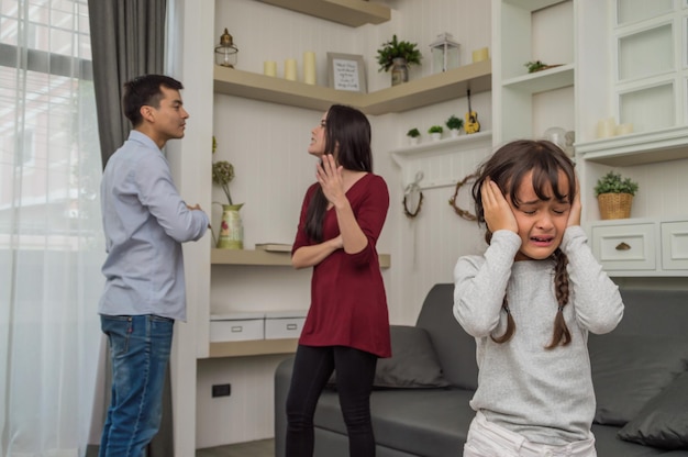 Photo parents arguing behind girl crying at home