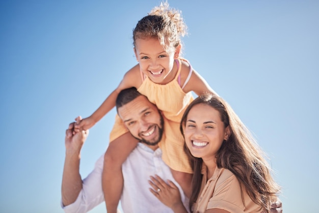 Genitori bambino e felice con il cielo dentro per ritratto di famiglia insieme fuori in vacanza mamma papà e ragazza sulle spalle amore e felicità all'aperto con cielo blu mentre sono in vacanza o in viaggio