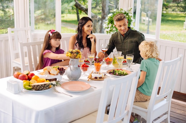 Parents and children eating salads while having lunch outside