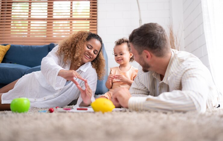 Parents and children relax in the living room of the house Watch baby paint on the paper happily
