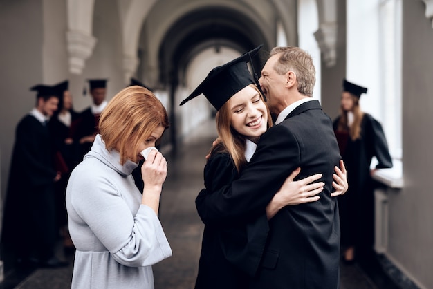 Родители поздравляют ученика, заканчивающего учебу.