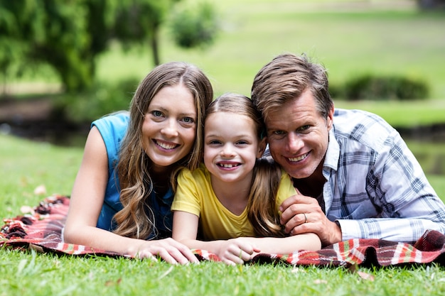 Parents and daughter lying in the park