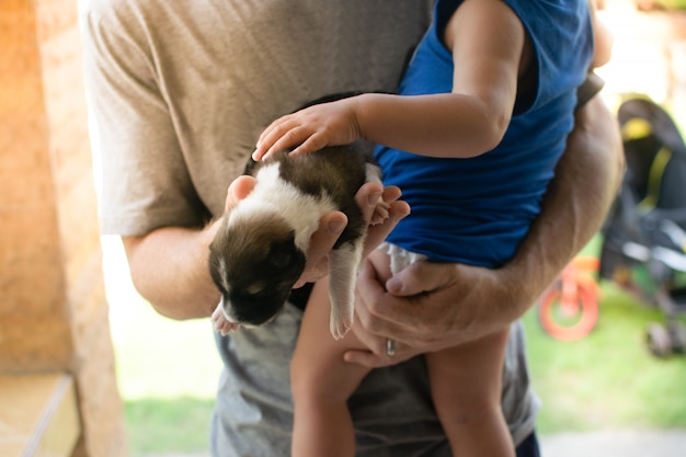 写真 両親は初めて子供に子犬を与える