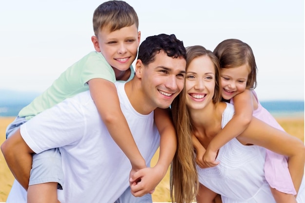 Parents giving piggyback ride to kids at the beach