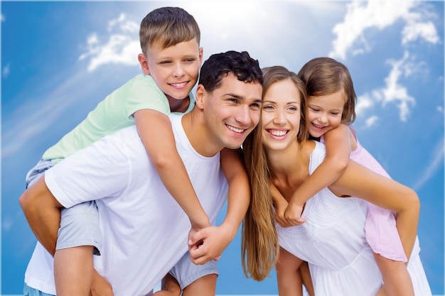 Parents giving piggyback ride to kids at the beach