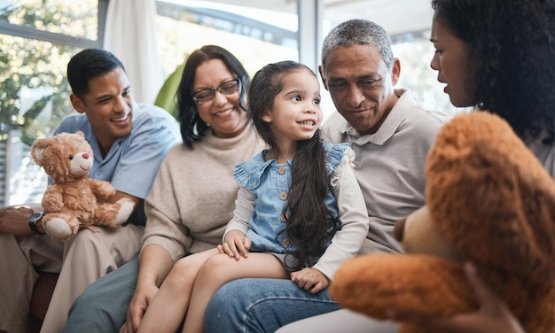 Parents grandparents and girl with teddy bear on sofa bonding and smile for family in home living room Men women and female child with toys love and happiness on lounge couch in house on holiday