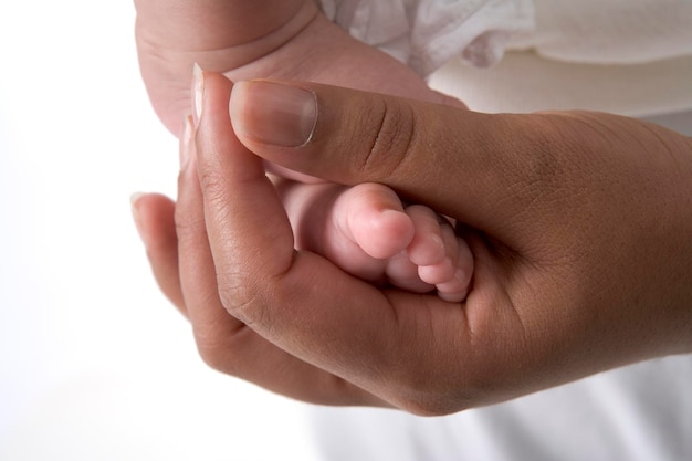 Parents hand holding little tiny baby foot