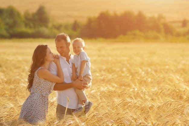 Родители счастья, гуляют по полю с ребенком