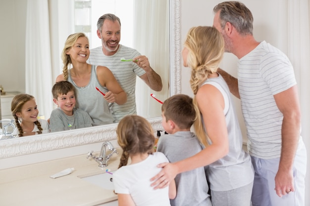 Photo parents and kids brushing teeth in bathroom