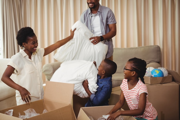 Parents and kids opening cardboard boxes in living room