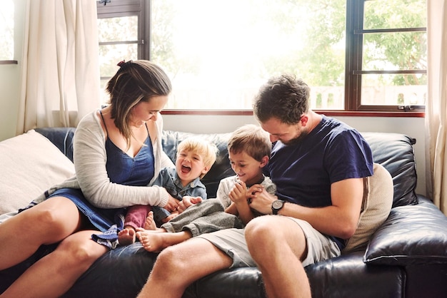 Photo parents and kids sitting on sofa at home