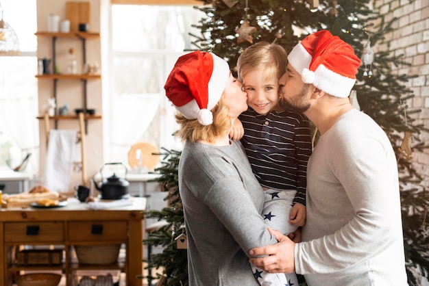 Photo parents kissing their boy on the cheeks with copy space