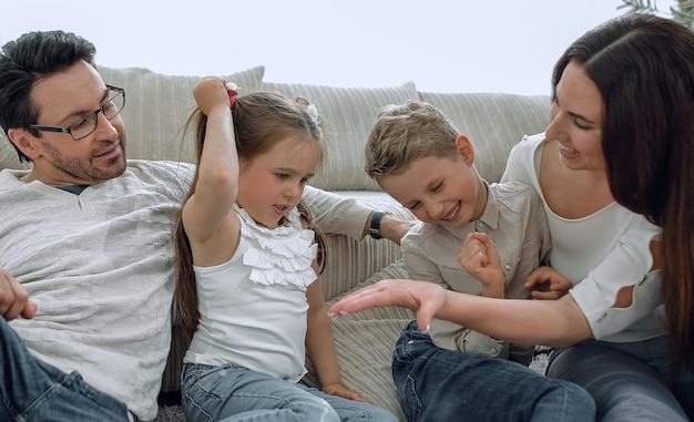 Parents play with children sitting on the carpet in the living
room