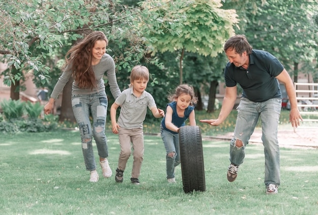 I genitori giocano con i loro bambini nel parco giochi vicino alla casa