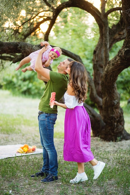 I genitori giocano con la loro piccola figlia durante un picnic nella natura