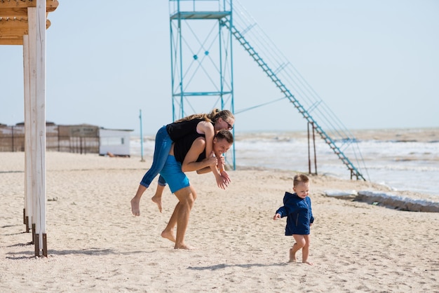 parents playing on the beach with their son