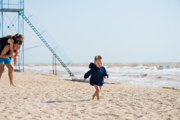 parents playing on the beach with their son