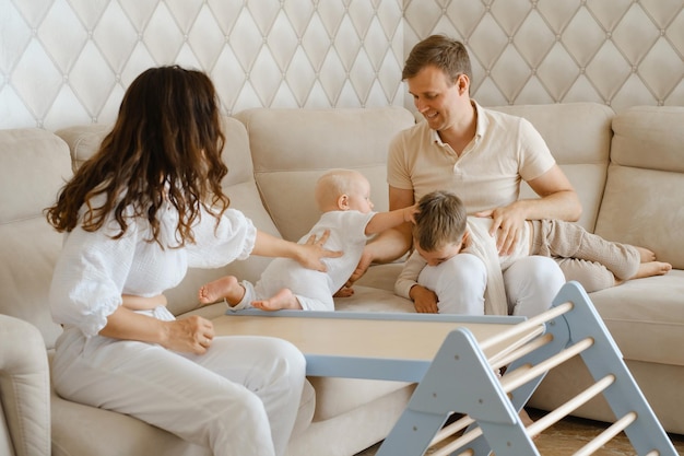 Parents playing with children on sofa in a cozy white apartment