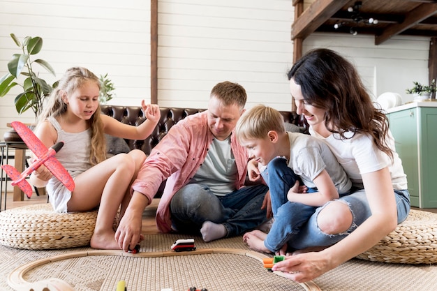 Photo parents playing with kids in living room